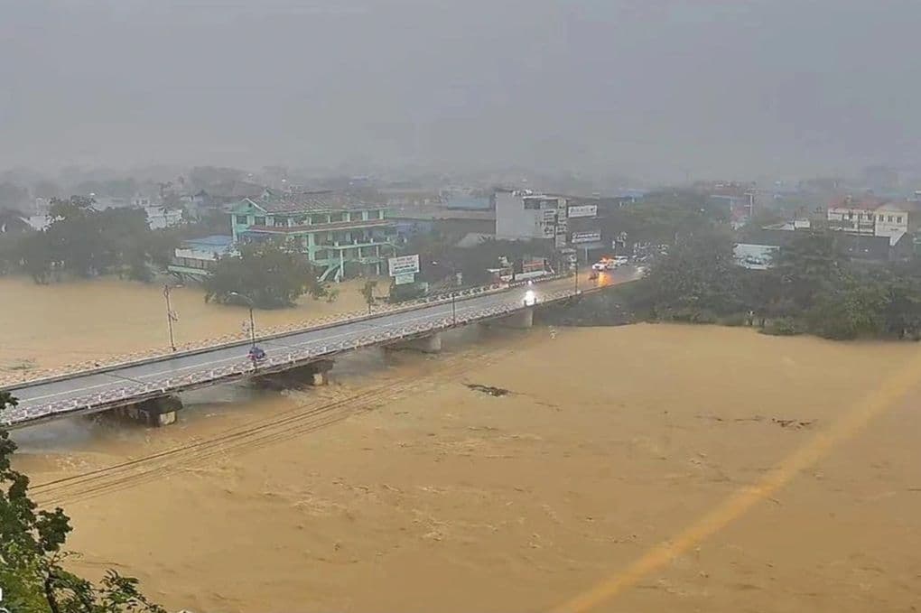 Cầu và đường ngập trong dòng nước lũ lớn, thể hiện nguy cơ lũ quét và sạt lở đất.