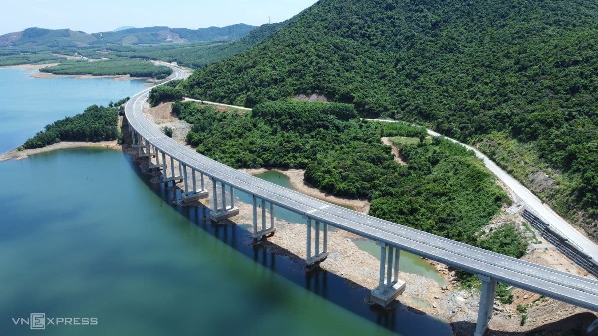 Cầu vượt cao tốc uốn lượn qua hồ nước và núi rừng, minh chứng cho các đại công trình giao thông hiện đại.