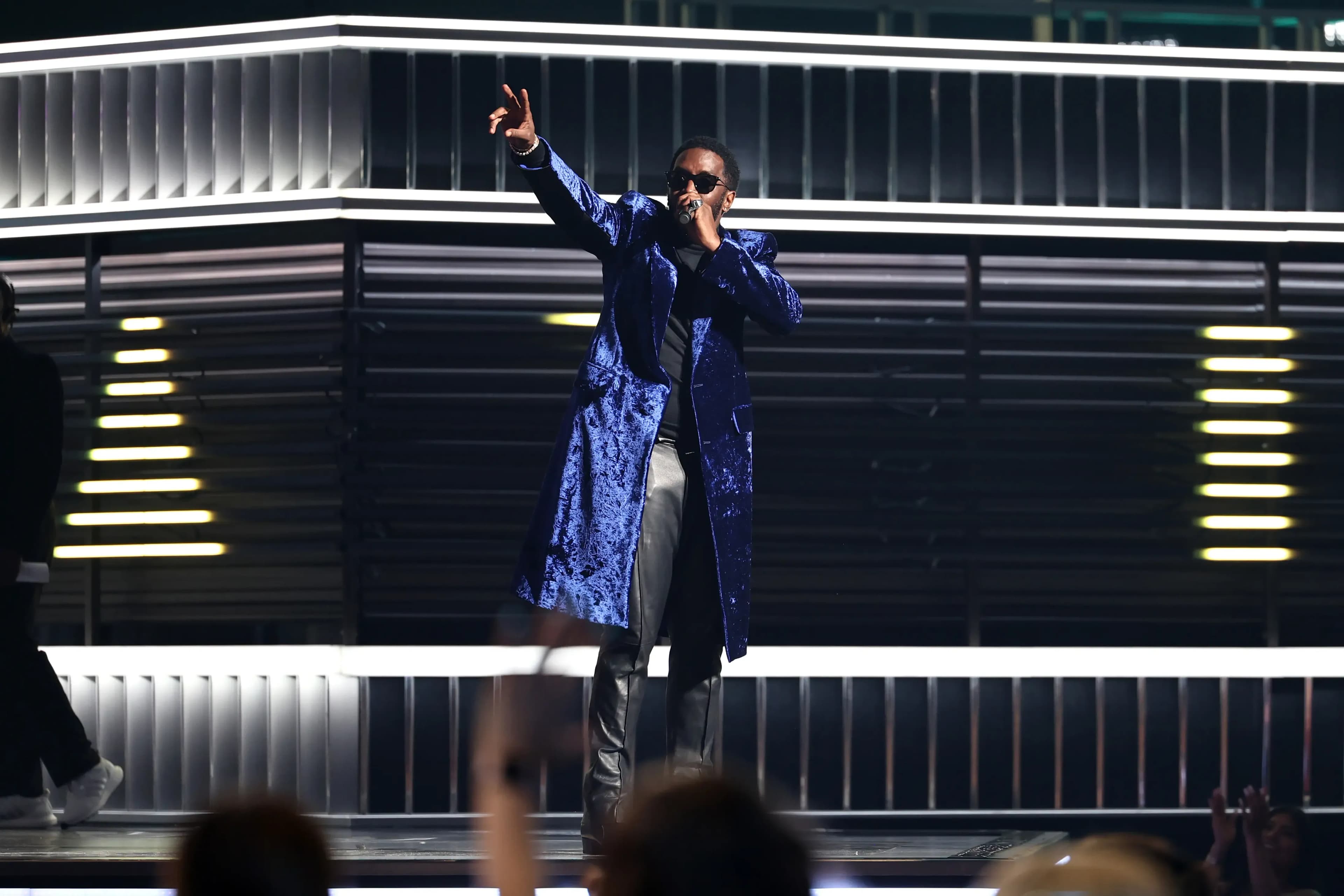 Diddy, biểu tượng hip-hop, biểu diễn trên sân khấu lộng lẫy, tượng trưng cho quyền lực và danh tiếng đã mất.