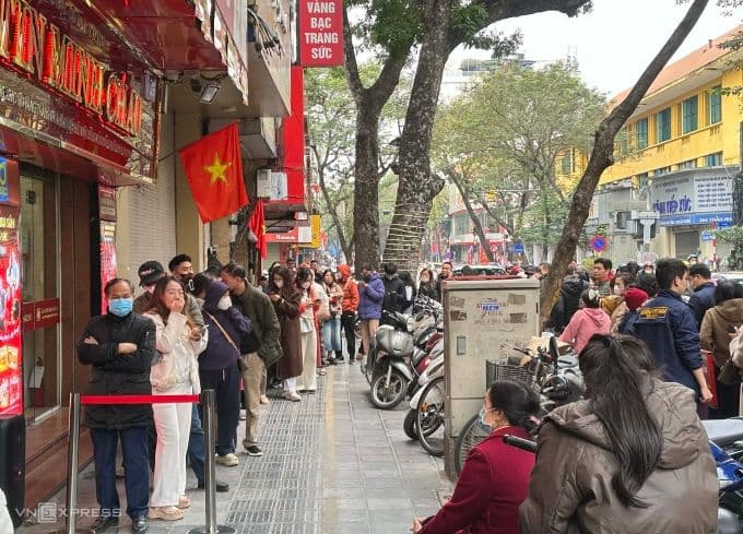 Dòng người xếp hàng dài bên ngoài cửa hàng Bảo Tín Minh Châu trên phố Trần Nhân Tông để mua vàng khi giá giảm sâu.