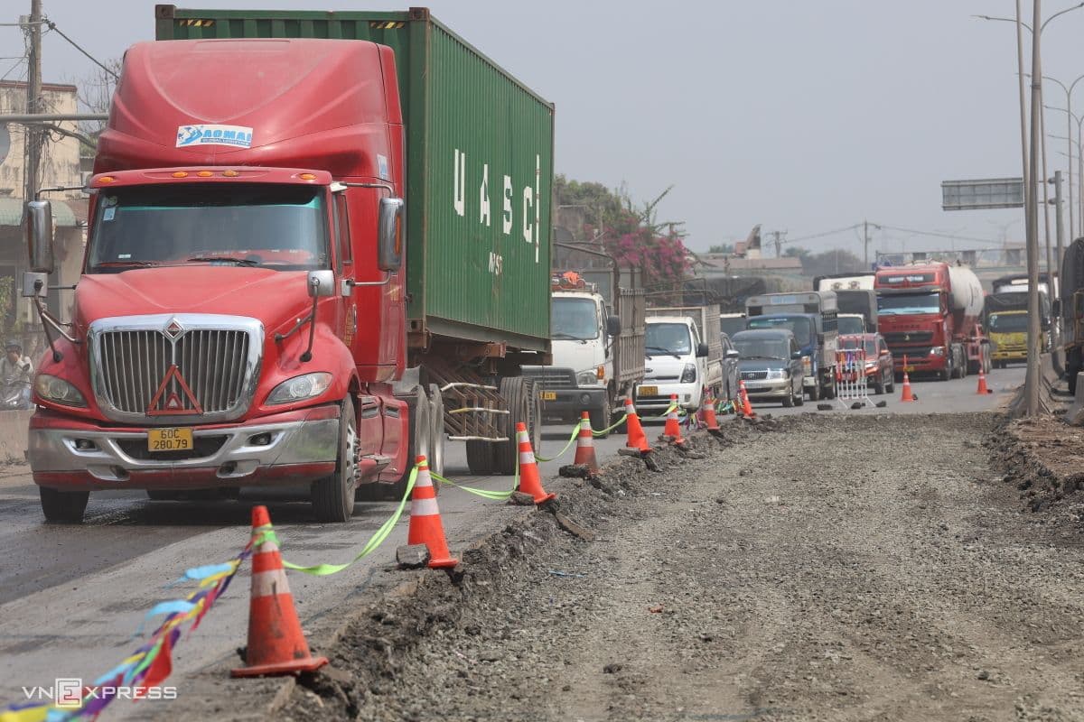 Dòng xe tải lớn xếp hàng dài cạnh khu vực đang thi công trên Quốc lộ 51, minh họa tình hình giao thông và đầu tư hạ tầng.