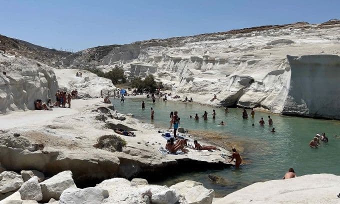Du khách thư giãn tại bãi biển Sarakiniko với những vách đá trắng độc đáo trên đảo Milos.