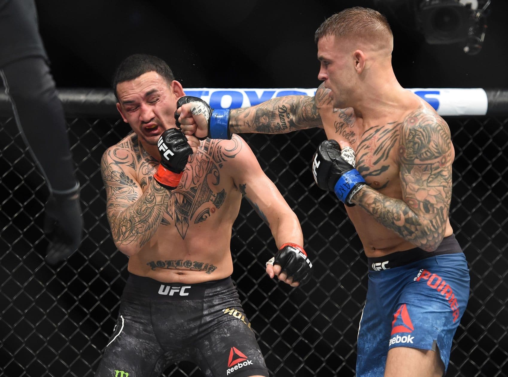 Dustin Poirier tung cú đấm vào Max Holloway trong lồng bát giác UFC.