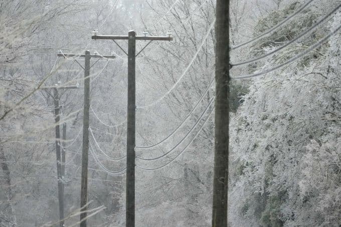 Dây điện và cây cối đóng băng trong mùa đông khắc nghiệt, tượng trưng cho những thách thức của thời tiết lạnh giá.