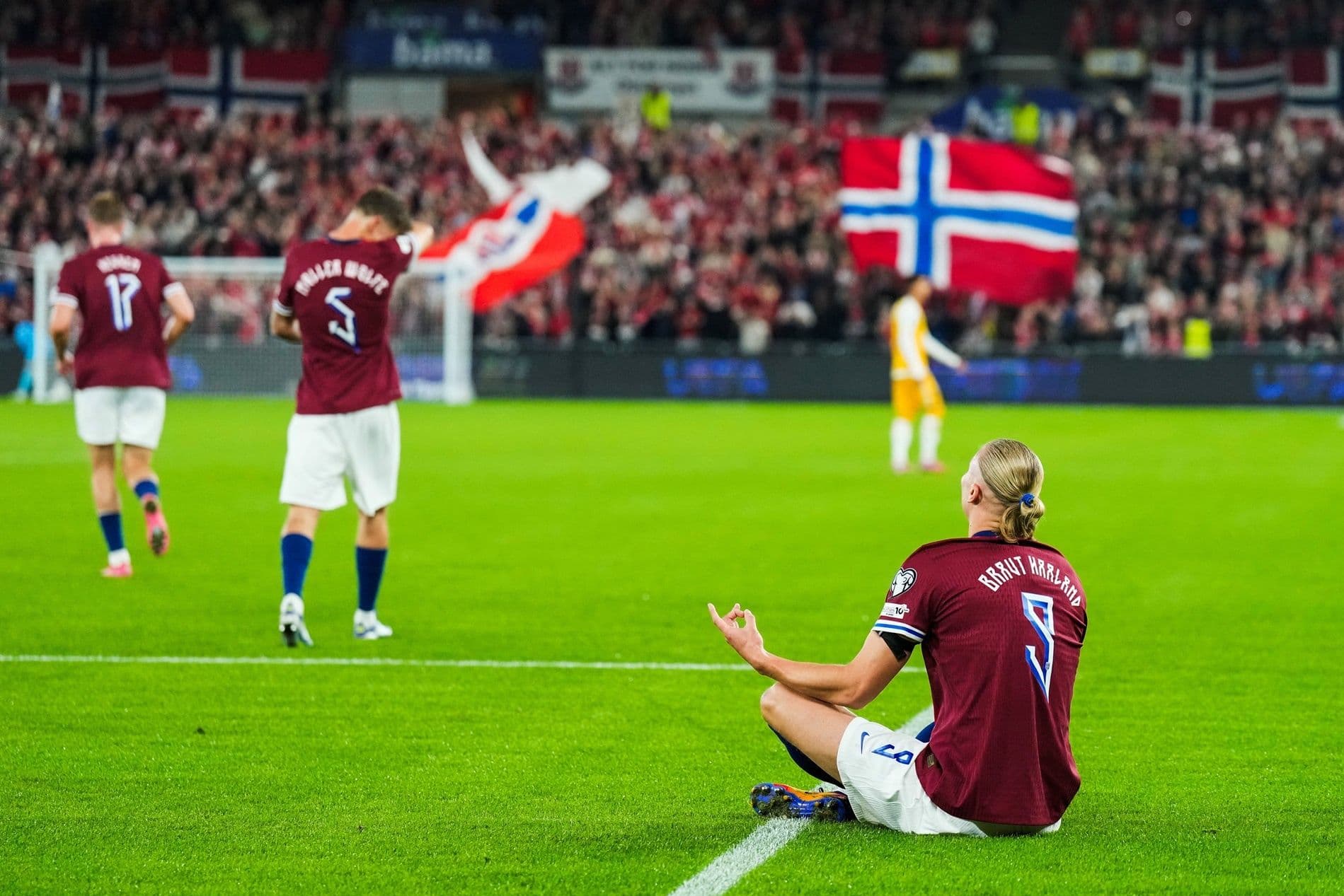 Erling Haaland ngồi trên sân cỏ sau khi ghi bàn trong trận Na Uy thắng đậm Moldova
