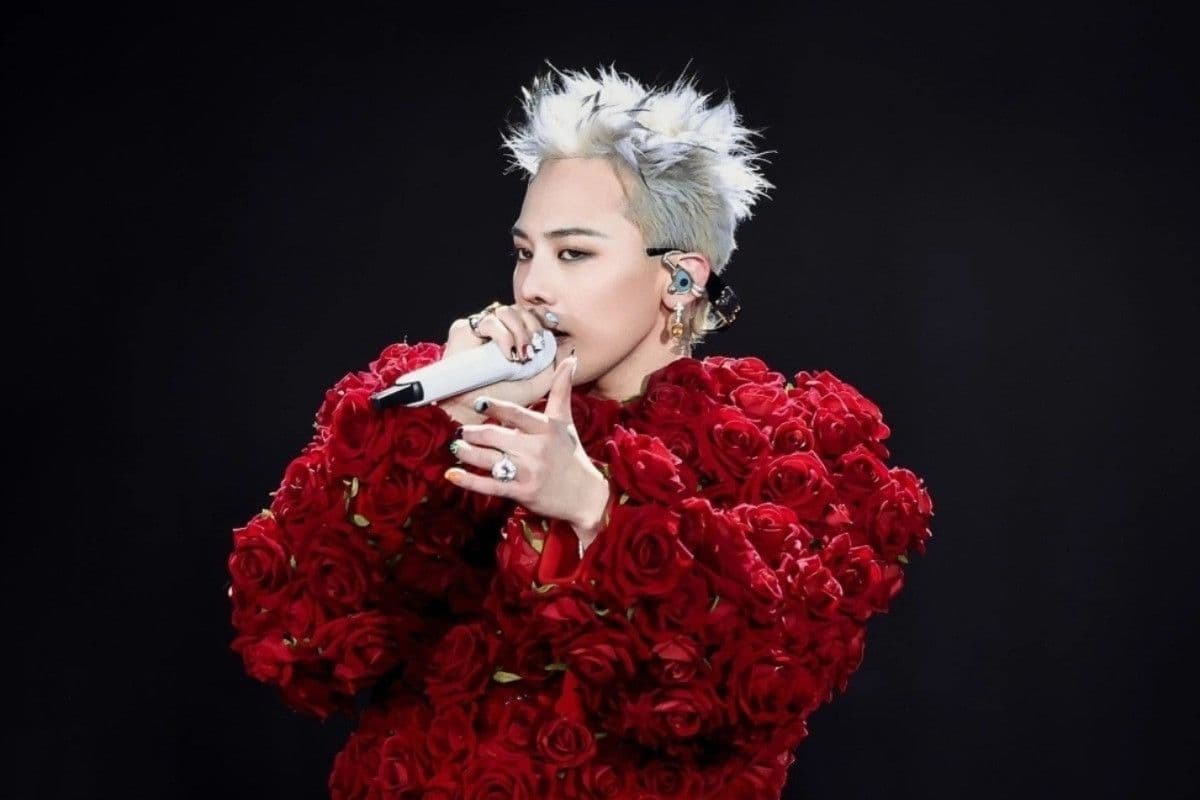 G-Dragon biểu diễn trên sân khấu với trang phục độc đáo đính hoa hồng đỏ, thể hiện phong cách biểu tượng của BIGBANG.