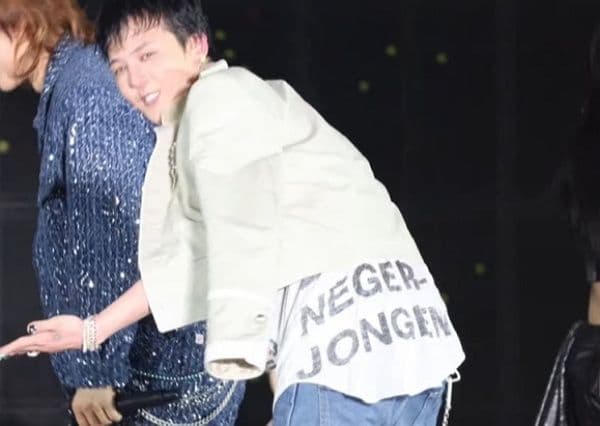 G-Dragon trên sân khấu với chiếc áo thun có dòng chữ gây tranh cãi về phân biệt chủng tộc.