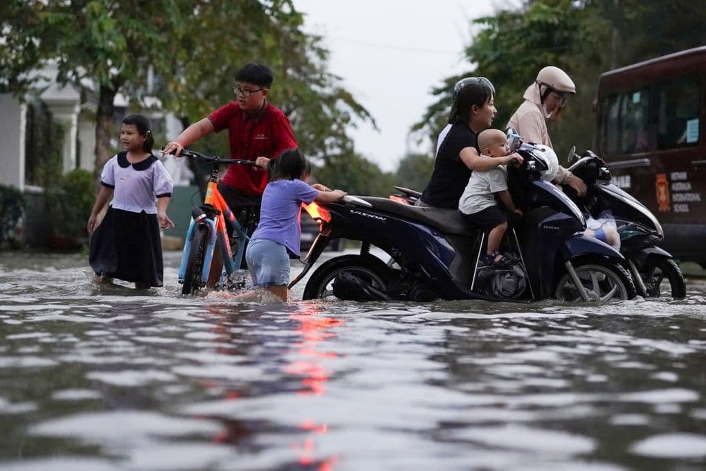 Gia đình chật vật di chuyển qua đường ngập, cuộc sống đảo lộn vì triều cường ở Sài Gòn.