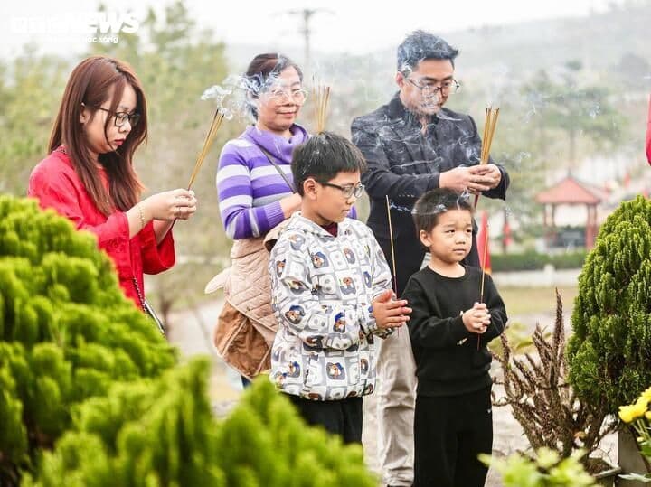 Gia đình nhiều thế hệ thành kính thắp hương và khấn nguyện tại mộ, thể hiện sự kết nối tâm linh với tổ tiên