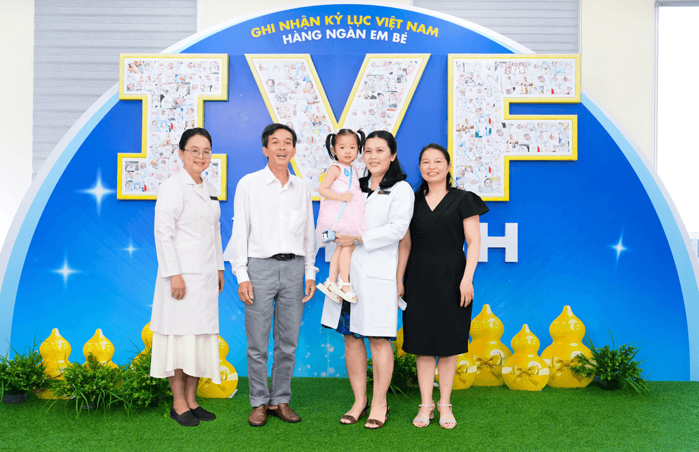 Gia đình và các y bác sĩ bên cạnh biểu tượng IVF, tượng trưng cho quyền năng sinh sản mới và tương lai Việt Nam.
