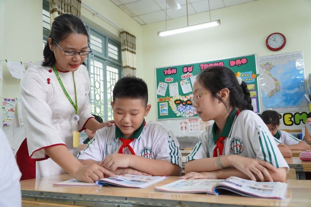 Giáo viên hướng dẫn học sinh trong lớp học, minh họa việc tái cấu trúc trường học và tối ưu hóa giáo dục