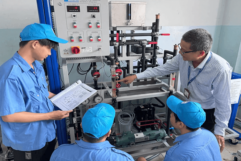 Giáo viên hướng dẫn sinh viên thực hành với thiết bị kỹ thuật
