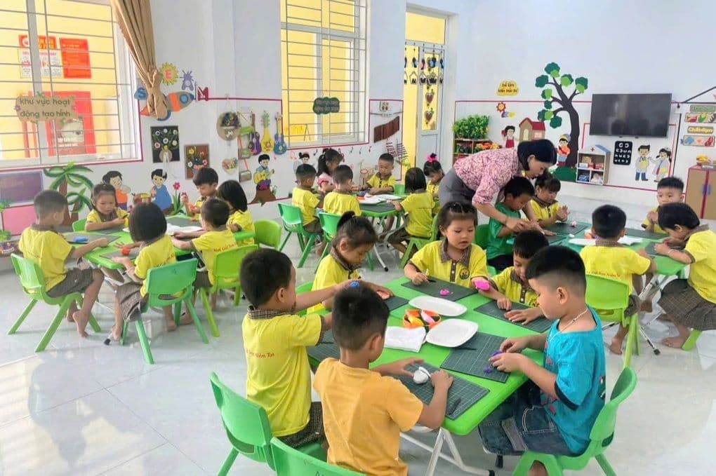 Giáo viên mầm non tận tình hướng dẫn các em nhỏ trong lớp học, thể hiện sứ mệnh 'trồng người'.