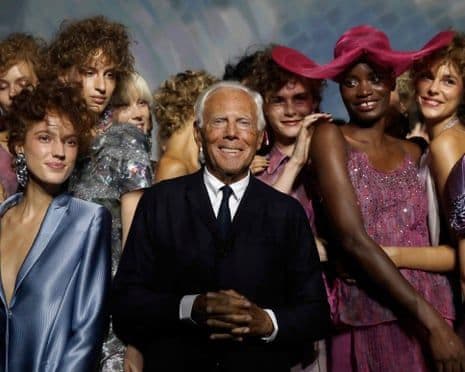 Giorgio Armani mỉm cười giữa các người mẫu sau buổi trình diễn bộ sưu tập của mình, thể hiện di sản thời trang và tầm ảnh hưởng của ông.