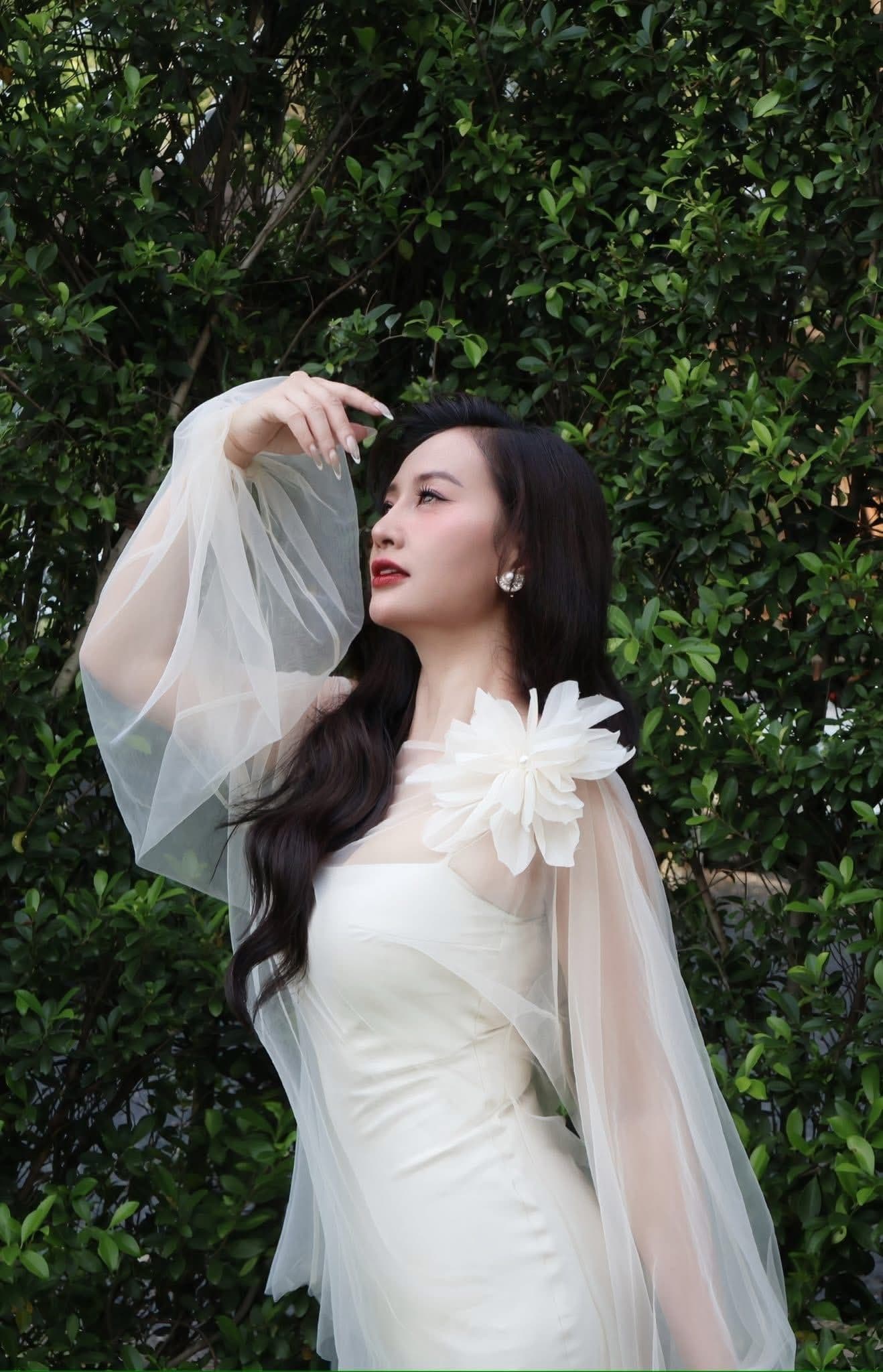 Hà Thúy Anh trong trang phục trắng thanh lịch, ánh mắt hướng về phía trước, tượng trưng cho hạnh phúc và sự tự chủ mới.