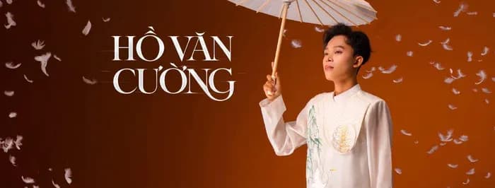 Hồ Văn Cường trong trang phục áo dài cách tân, cầm ô, thể hiện sự trưởng thành và nghệ thuật của anh.