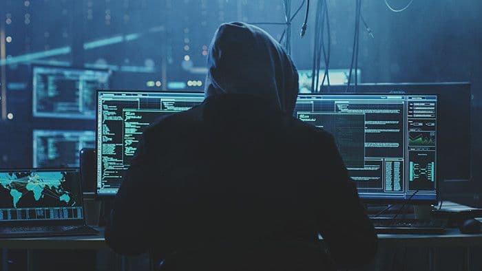 Hacker đang thực hiện tấn công mạng vào hệ thống máy tính, tượng trưng cho mối đe dọa an ninh mạng.