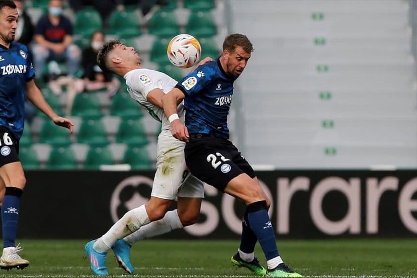 Hai cầu thủ Alaves và Elche tranh chấp bóng trong trận đấu La Liga