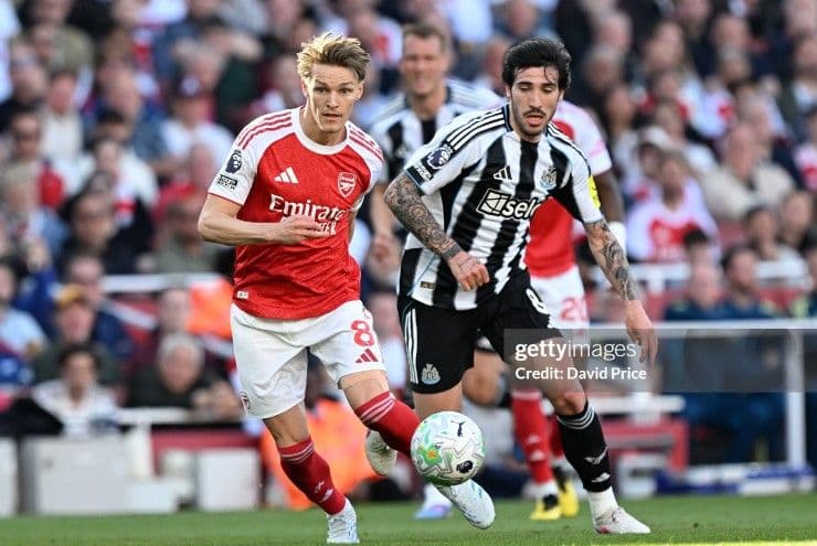Hai cầu thủ Arsenal và Newcastle tranh bóng quyết liệt trong trận đấu Ngoại hạng Anh