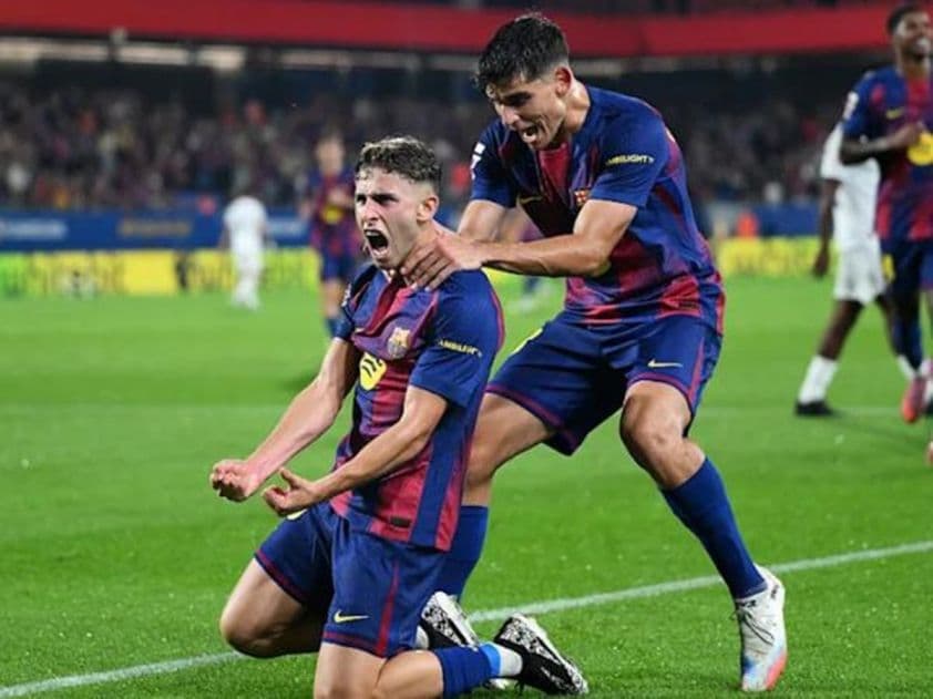 Hai cầu thủ Barcelona ăn mừng bàn thắng, thể hiện sức mạnh tấn công áp đảo của đội.