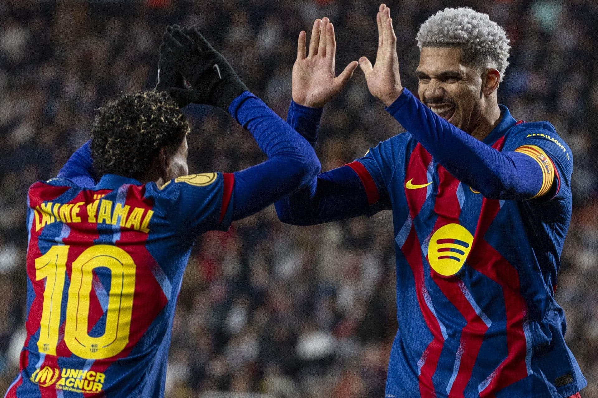 Hai cầu thủ Barcelona ăn mừng bàn thắng, thể hiện tinh thần đồng đội và sự tự tin.