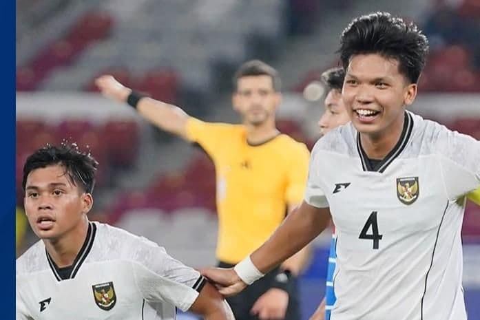 Hai cầu thủ bóng đá đang ăn mừng chiến thắng trên sân.