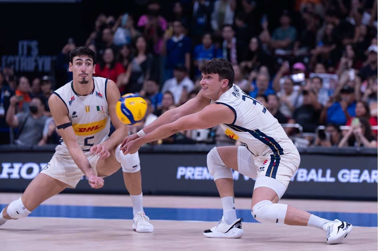 Hai cầu thủ bóng chuyền Ý đang thực hiện pha đỡ bóng trong trận đấu trực tiếp, thể hiện sự kịch tính của bóng chuyền.