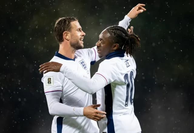 Hai cầu thủ bóng đá ôm nhau trên sân, thể hiện cảm xúc mãnh liệt của các trận đấu vòng loại World Cup.