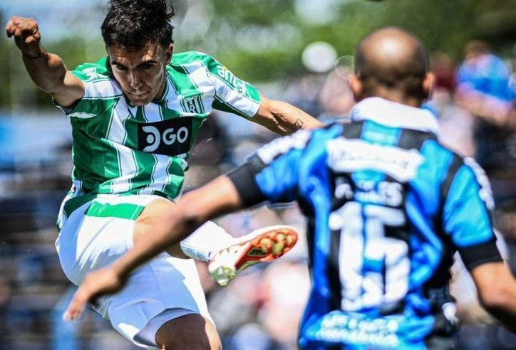 Hai cầu thủ bóng đá tranh chấp bóng quyết liệt, thể hiện lối chơi phòng ngự phản công của Paraguay.