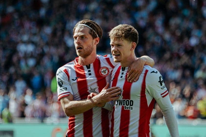 Hai cầu thủ Brentford trên sân cỏ, thể hiện sự tập trung trước trận đấu cúp EFL với Birmingham.