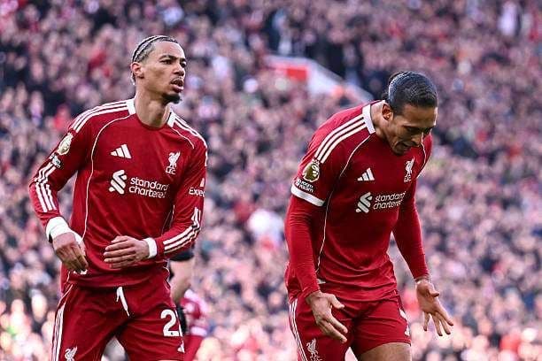 Hai cầu thủ Liverpool trên sân cỏ, thể hiện cảm xúc sau một trận đấu Ngoại Hạng Anh