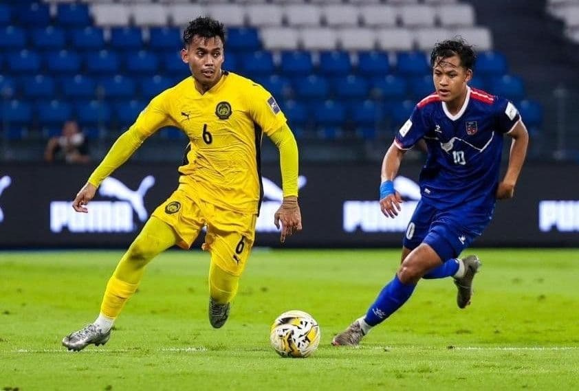 Hai cầu thủ Malaysia và Lào tranh bóng quyết liệt trong trận đấu AFF Cup