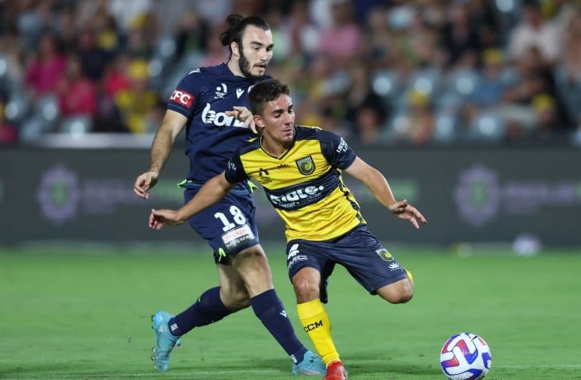 Hai cầu thủ Melbourne Victory và Central Coast Mariners tranh bóng trong trận đấu A-League.