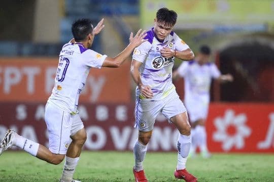 Hai cầu thủ ăn mừng chiến thắng, tượng trưng cho ý nghĩa của ba điểm và tác động đến tâm lý, vị thế của đội bóng trong mùa giải.