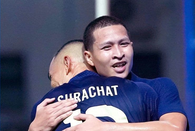 Hai cầu thủ Thái Lan ăn mừng bàn thắng, tượng trưng cho niềm tự hào và thách thức đổi mới.