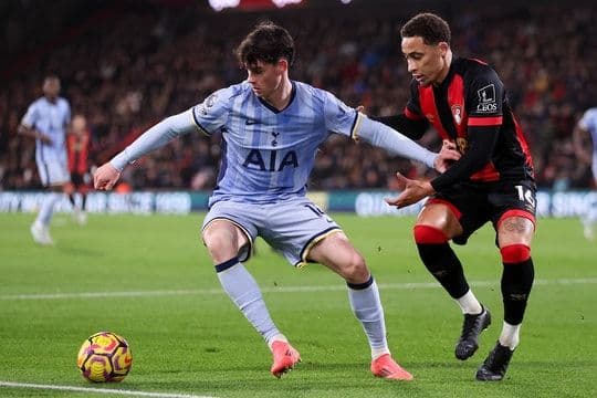 Hai cầu thủ tranh chấp bóng quyết liệt trên sân cỏ Ngoại hạng Anh, thể hiện tinh thần chiến đấu.