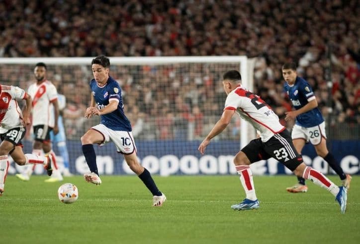 Hai cầu thủ tranh chấp bóng quyết liệt trên sân, thể hiện tính chất căng thẳng và nhiều va chạm của trận đấu.