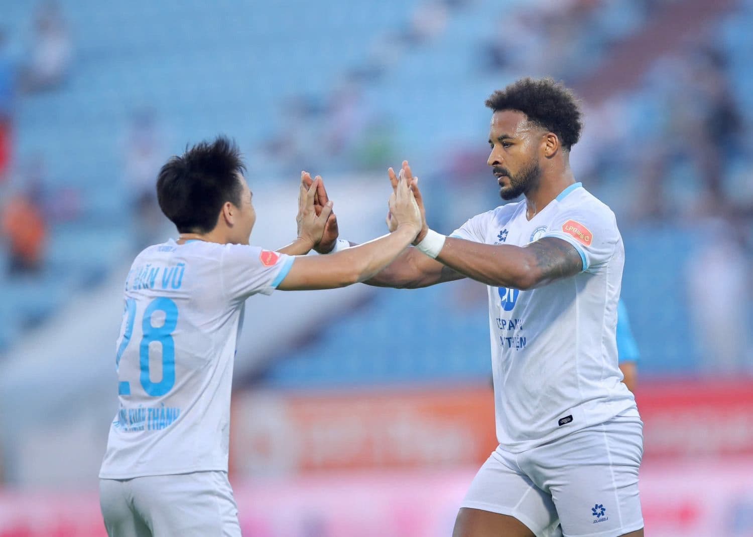 Hai cầu thủ V-League ăn mừng bàn thắng, biểu tượng cho tinh thần thể thao và sự phát triển của bóng đá Việt Nam.