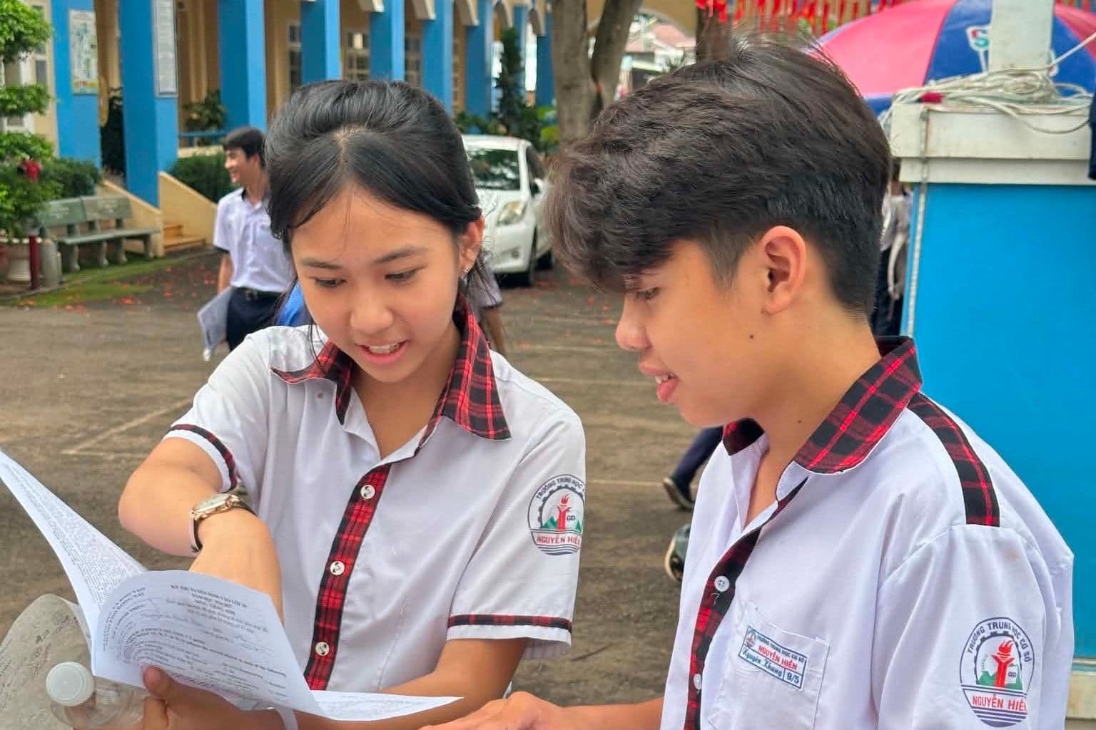 Hai học sinh Đà Nẵng thảo luận kết quả hoặc đề thi lớp 10, thể hiện sự phân hóa năng lực giữa các môn.