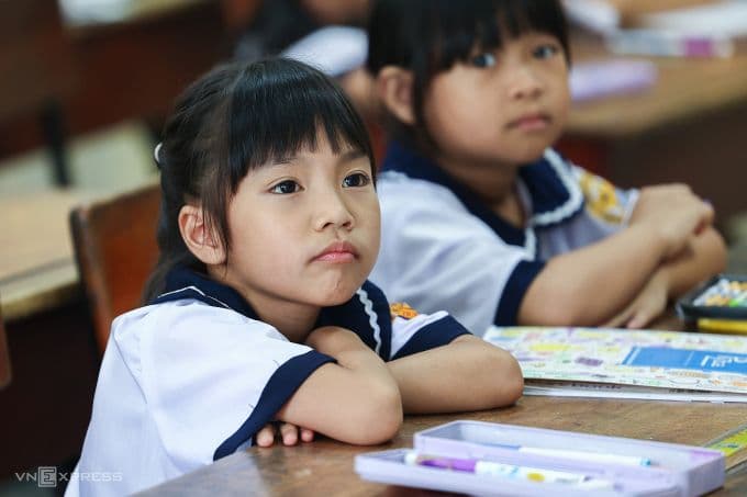 Hai học sinh tiểu học chăm chú học bài, tượng trưng cho mục tiêu giáo dục nhân văn và cơ hội tiếp cận tri thức bình đẳng trong kỷ nguyên số.