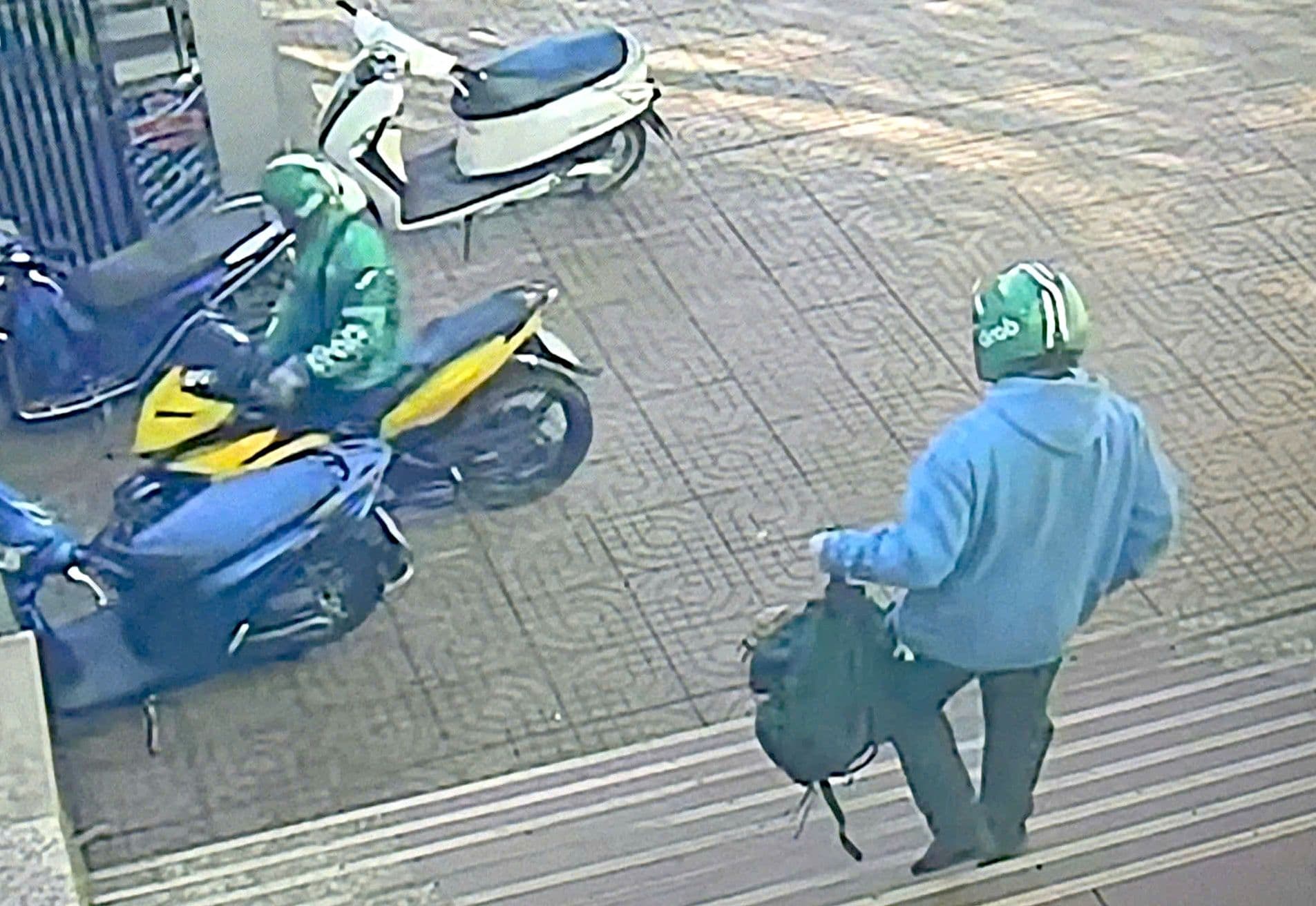 Hai đối tượng cướp ngân hàng mặc trang phục Grab rời khỏi hiện trường trên xe máy.