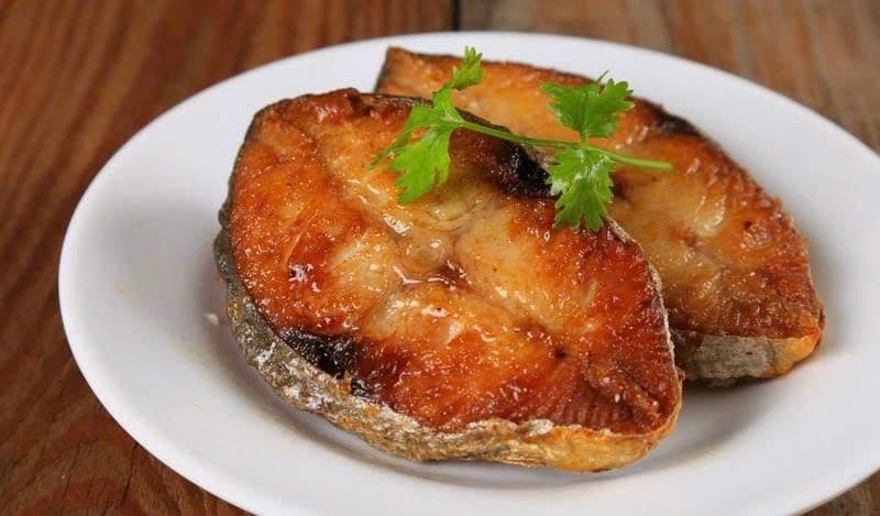 Hai miếng cá chiên vàng ươm, minh họa món ăn cần được chế biến và tiêu thụ hợp lý để bảo vệ sức khỏe thận.
