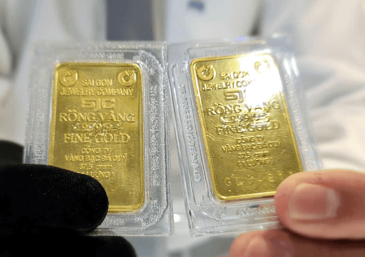 Hai miếng vàng SJC được giữ trên tay, tượng trưng cho biến động giá vàng trên thị trường sau chỉ đạo của Thủ tướng.