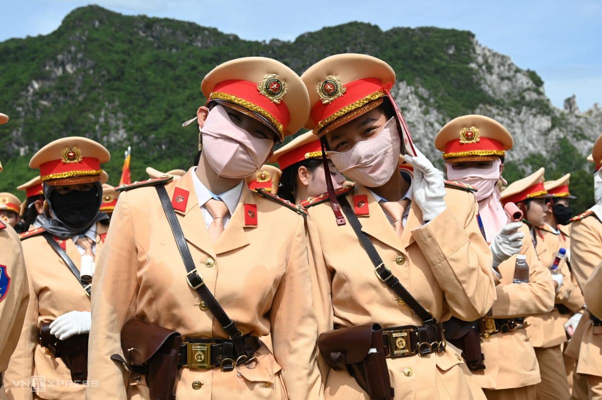 Hai nữ cảnh sát giao thông Việt Nam đeo khẩu trang chống nắng trong buổi tổng duyệt diễu binh, thể hiện sự hy sinh thầm lặng.
