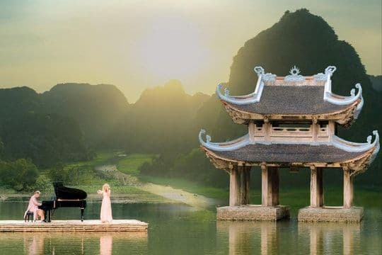 Hai nghệ sĩ biểu diễn âm nhạc giữa khung cảnh thiên nhiên hùng vĩ và kiến trúc truyền thống, tượng trưng cho sức mạnh chữa lành và truyền cảm hứng của nhạc xuân.