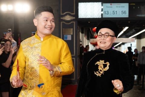 Hai nghệ sĩ trong trang phục truyền thống biểu diễn, thể hiện sự giao thoa văn hóa Tết.