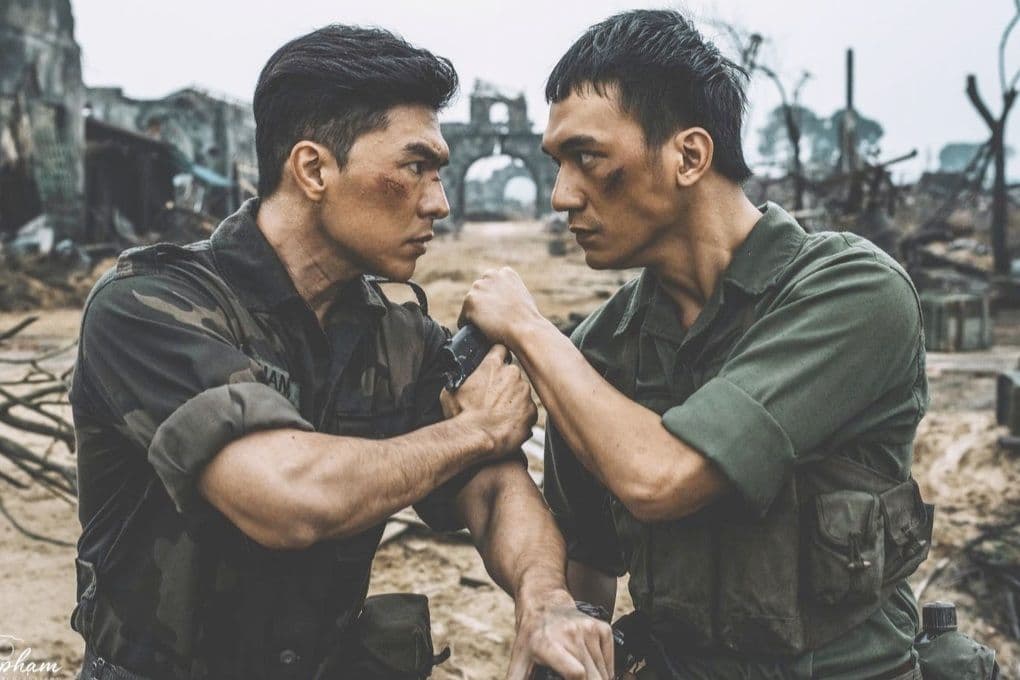Hai người lính với gương mặt lấm lem, ánh mắt kiên định trong bối cảnh chiến tranh, đại diện cho phim 'Mưa Đỏ'.