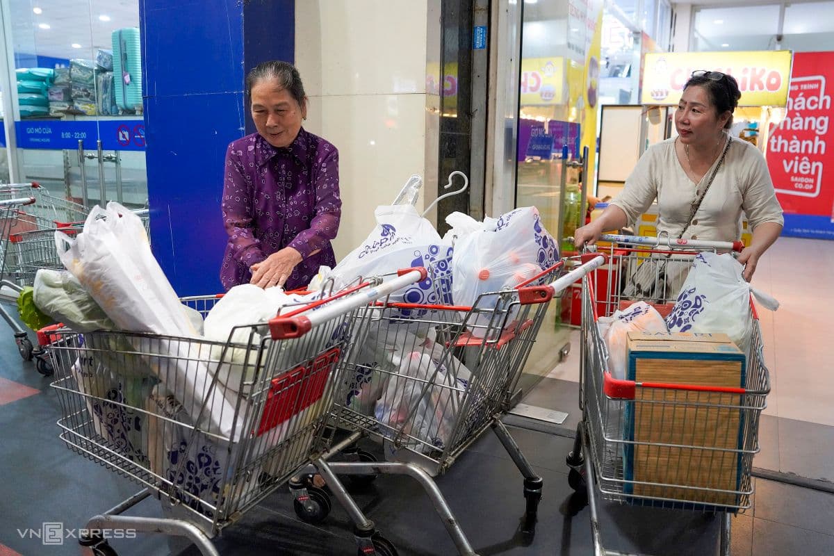 Hai người phụ nữ với nhiều xe đẩy đầy ắp hàng hóa, thể hiện sự chuẩn bị kỹ lưỡng của cộng đồng Đà Nẵng trước bão.