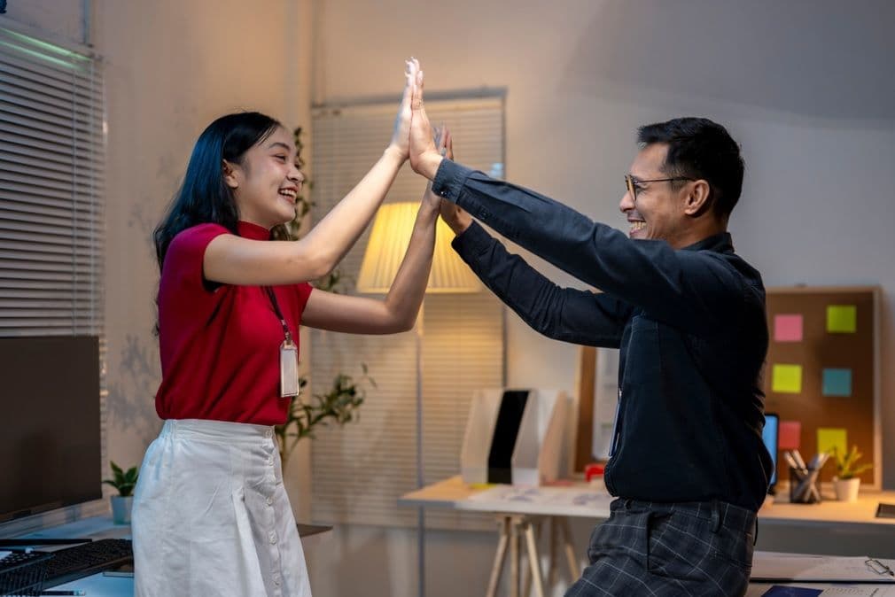 Hai người vui vẻ đập tay thể hiện sự thành công và hợp tác