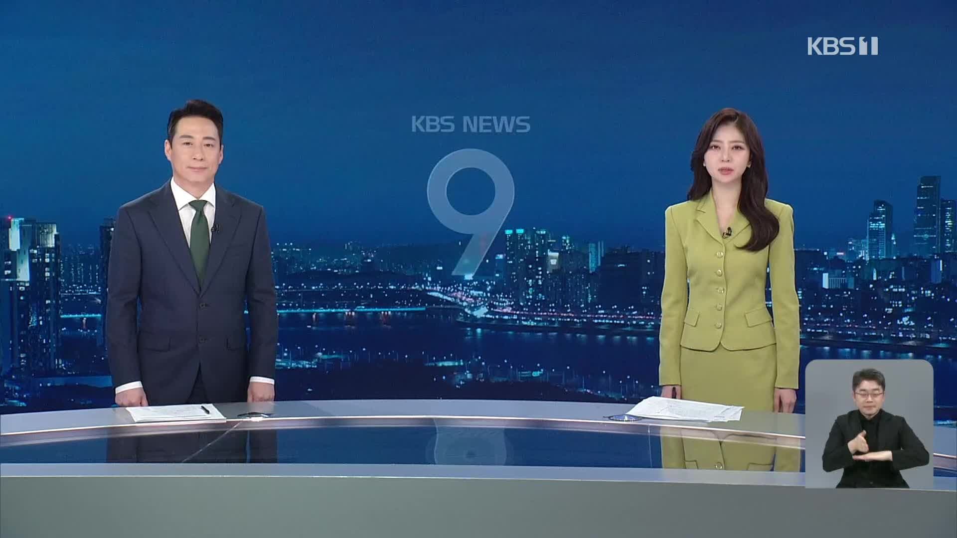 Hai phát thanh viên tin tức đang trình bày tại trường quay KBS NEWS 9, đại diện cho việc cung cấp thông tin thời tiết và lời khuyên an toàn.